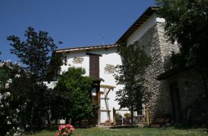 a large stone house with trees and flowers at Casale Le Due Querce in Ferentillo