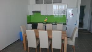 a kitchen with a wooden table and white cabinets at Beautiful Apartment Jukic in Podstrana +10 photos