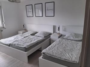 two beds in a room with white walls at Gemütliche Ferienwohnung in Karlsruhe in Karlsruhe