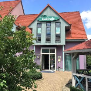 un bâtiment violet et vert avec un panneau sur lui dans l'établissement Hotel Ambiente, à Halberstadt