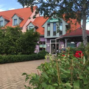 un groupe de bâtiments avec des fleurs devant eux dans l'établissement Hotel Ambiente, à Halberstadt