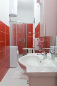 Apartments Svilan في تروغير: حمام مع حوض أبيض وبلاط احمر