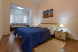 1 dormitorio con 1 cama con manta azul en Apartments Svilan, en Trogir