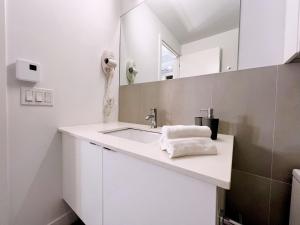 Tiny Penthouse Big Balcony Central & Cozy في مونتريال: حمام أبيض مع حوض ومرآة +47 صورة