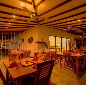 a dining room with wooden tables and chairs at Hotel Longteng in Sigiriya