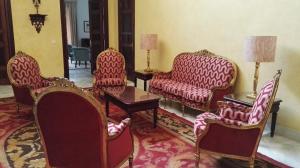 a living room with red chairs and a table at Hotel Duques de Medinaceli in El Puerto de Santa María