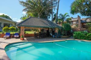 a swimming pool in front of a house at Whalesong Guest House in St Lucia