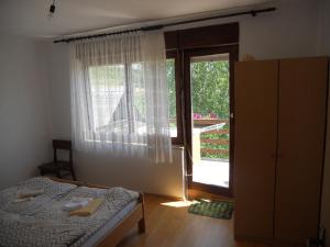 a bedroom with a bed and a large window at Apartman Došen in Ličko Petrovo Selo
