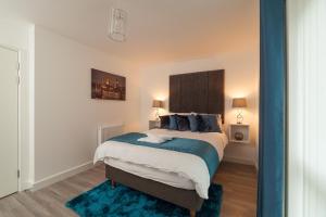 een slaapkamer met een groot bed en een blauw tapijt bij Luxury In2 London Apartment in Londen