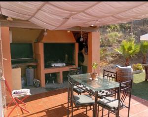 a patio with a table and chairs under a tent at Casa para fines de semana cuevas del turche buñol in Buñol