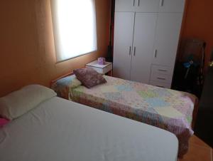 a small bedroom with two beds and a window at Casa para fines de semana cuevas del turche buñol in Buñol