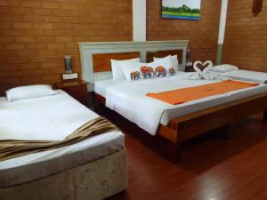 two beds in a hotel room with two at Elephas Nature Resort in Sigiriya