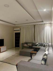 a living room with a couch and a tv at Al Murjan Compound Villa in Jeddah