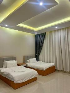 two beds are in a room with a ceiling at Al Murjan Compound Villa in Jeddah