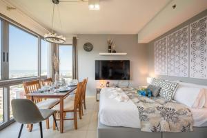 a bedroom with a bed and a dining room with a table at Unixx Pattaya by Chanakan in Pattaya South