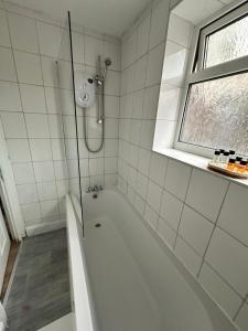 a white bathroom with a tub and a window at 3 Bed Near Coventry Arena, Contractor & Family Accommodation in Coventry +6 photos