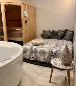a bathroom with a bed and a table and a bath tub at Vila Brinje in Dol pri Ljubljani