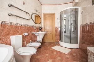 a bathroom with a toilet and a sink and a shower at Ginger Apartment Riga in Rīga +4 photos
