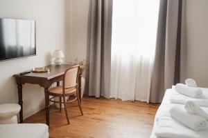 a room with a desk and a bed and a table at Stara šola Kaval in Novo Mesto