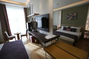 a hotel room with a bed and a desk with a television at Wes Hotel in Kocaeli