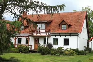 une maison blanche avec un toit rouge dans l'établissement Gospodarstwo Agroturystyczne Zielone Wzgórze, à Budry