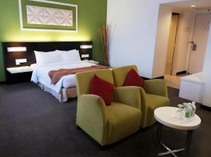 a bedroom with a bed and a couch and a chair at Grand Barakah Hotel in Kuala Lumpur +26 photos