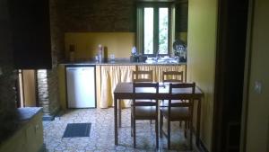 a kitchen with a table and chairs and a refrigerator at A Cabana de Cao in Loiba