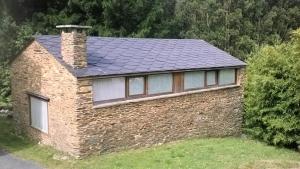 a brick house with a chimney on top of it at A Cabana de Cao in Loiba