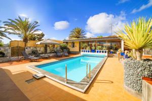 a swimming pool in the backyard of a house at Villa MADORA - private pool, amazing garden, sea view, quiet location in Tías