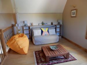 um pequeno quarto com uma cama e uma mesa em Le Hibou Heureux em Bézenac