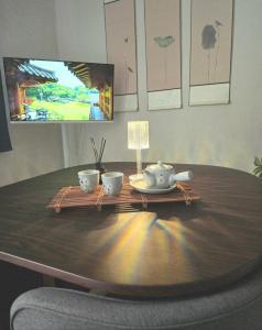 a wooden table with two tea cups and a tv at Slow accommodation,Free parking,kspo dome,Kangdong Sacred Heart Hospital,Seoul Asan Hospital,COEX,Lotte World Tower,kspo in Seoul