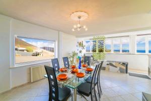 a dining room with a glass table and chairs at Villa MADORA - private pool, amazing garden, sea view, quiet location in Tías
