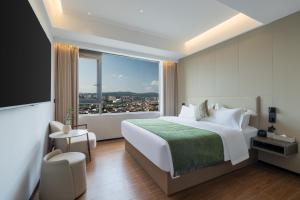 a hotel room with a bed and a large window at 张家界天门山索道站 Xiaduo B&B - 夏朵民宿-Planning-book Tickets Service in advance-Free Luggage in Wangjiazhai