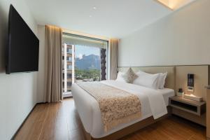 a bedroom with a white bed and a large window at Xiaduo B&B in Wangjiazhai