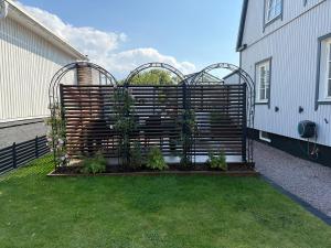 a wooden fence with plants in a yard at Gamletull Guesthouse in Halmstad