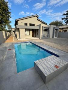 a swimming pool in front of a house at Kasane Boutique House in Kasane