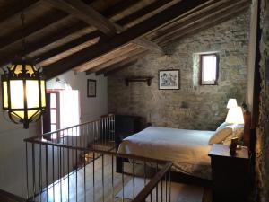 1 dormitorio con cama y pared de piedra en Charming House Óbidos, en Óbidos
