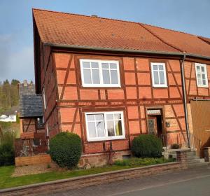 a brown house with white windows on a street at Ferienhaus Wesertal Monteur in Gottstreu