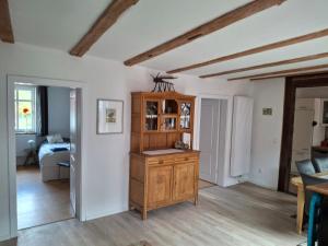 a living room with a wooden cabinet and a bedroom at Ferienhaus Wesertal Monteur in Gottstreu +4 photos