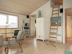 a living room with a ladder and a chair at 4 person holiday home in Gudhjem-By Traum in Gudhjem