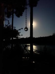 a light bulb hanging from a pole in front of the moon at The Mökki in Hult