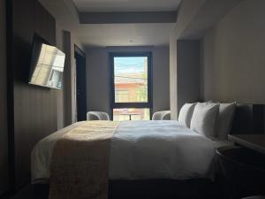 a bedroom with a large white bed with a window at hotel bolam kyoto in Shimo-dachiyuuridōri