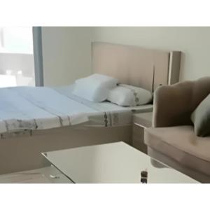 Zimmer mit einem Bett, einem Sofa und einem Stuhl in der Unterkunft استوديو فاخر مفروش في الشارقة الزاهية in Sabkhah