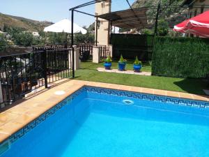 una piscina de agua azul en un patio en Hotel Rural Huerta del Laurel, en Monachil