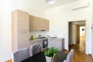 ローマにあるCS Cosy Termini Apartmentのキッチン(木製キャビネット、テーブル、椅子付)