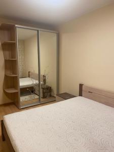 une chambre avec un lit et un miroir dans l'établissement Затишна квартира КОМФОРТ, à Oujhorod