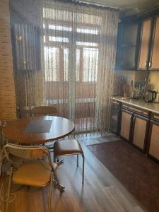 une cuisine avec une table et des chaises et une fenêtre dans l'établissement Затишна квартира КОМФОРТ, à Oujhorod