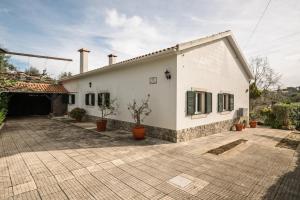 a white house with a courtyard with potted plants at Bela Vista - Countryside home in Gradil
