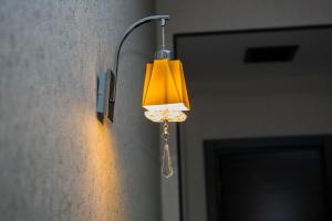 una luz en una pared con una lámpara amarilla. en Azalea Hotel Baku, en Baku