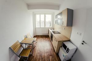 a small kitchen with two chairs and a table at Penzion Karolinka in Kroměříž